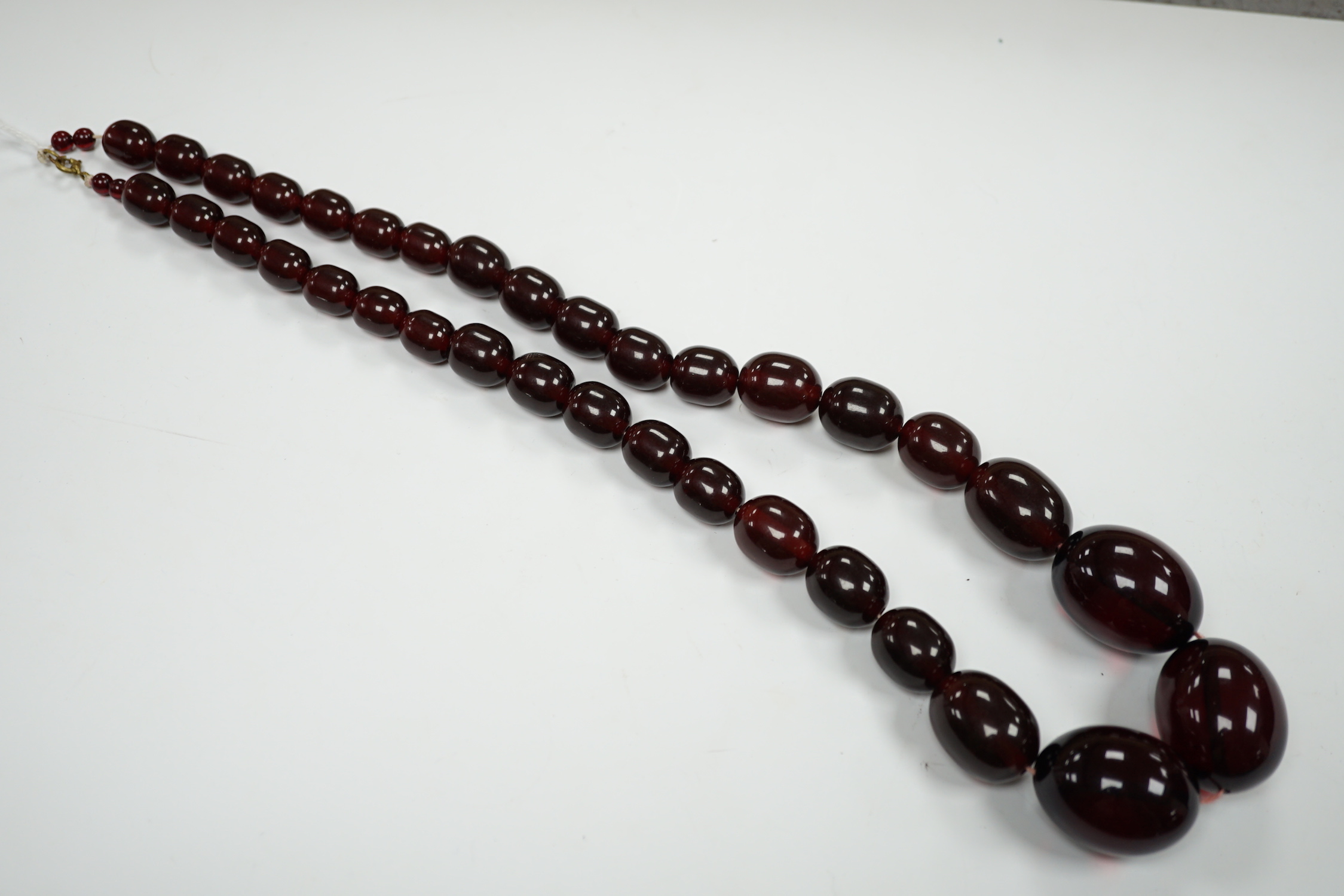 A single strand graduated simulated cherry amber bead necklace, 68cm, gross weight 151 grams.